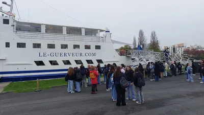 Les élèves font la queue sur le quai pour embarquer à bord du Guerveur
