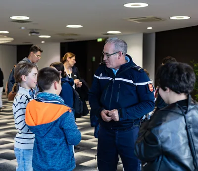 Un membre des forces de l'ordre en uniforme échange avec des élèves