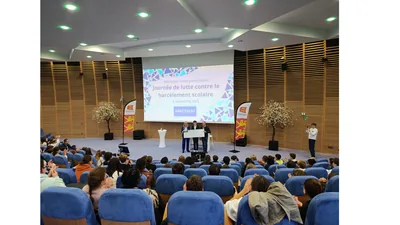 Remise de chèque sur scène devant l'écran de remerciement du 6 novembre 2025